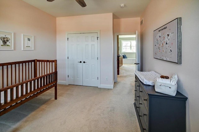 bedroom featuring light carpet, baseboards, visible vents, a ceiling fan, and a closet