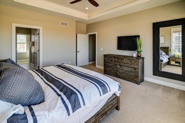 bedroom featuring light carpet, baseboards, visible vents, and a tray ceiling