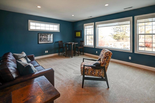 sitting room featuring carpet floors, visible vents, and a healthy amount of sunlight