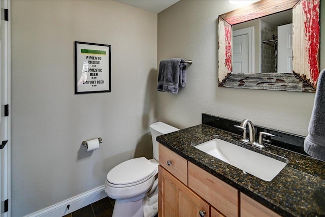 bathroom with toilet, tile patterned floors, baseboards, and vanity