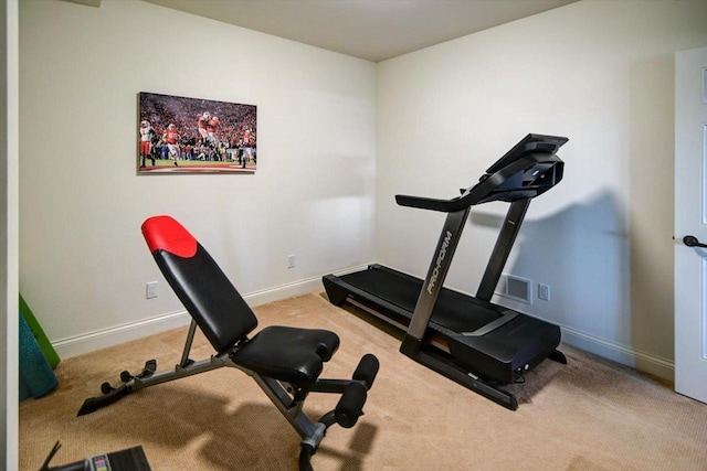 workout area featuring baseboards, visible vents, and light colored carpet