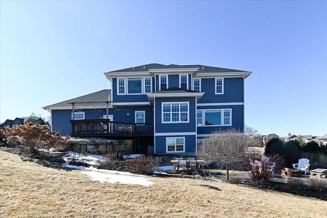 back of property featuring a yard and a wooden deck