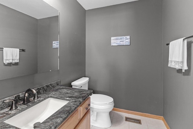 bathroom featuring visible vents, baseboards, toilet, tile patterned flooring, and vanity