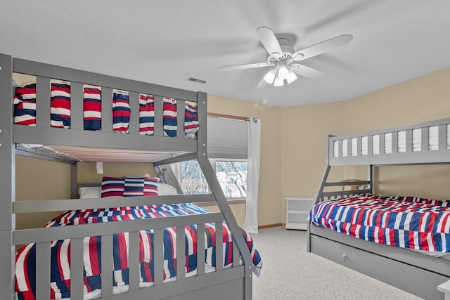 carpeted bedroom with a ceiling fan, visible vents, and baseboards