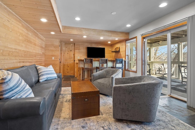 living area with recessed lighting, stone tile flooring, and wooden walls