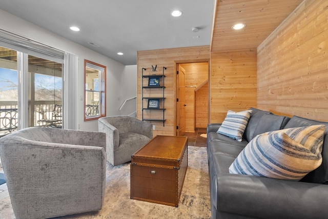 living area with recessed lighting, visible vents, and wooden walls