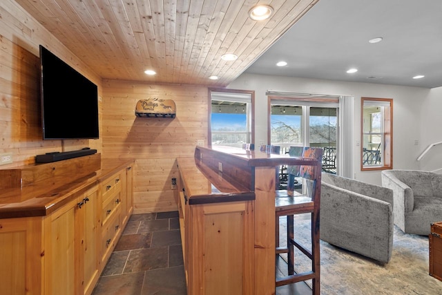 bar with recessed lighting, wooden ceiling, stone finish flooring, and wood walls