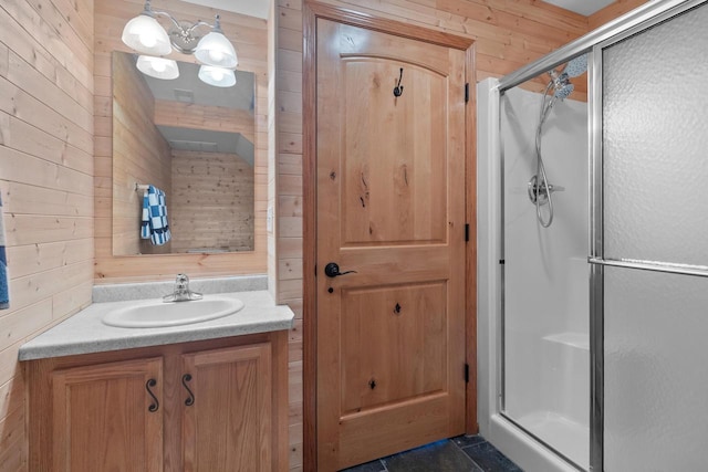 bathroom with wood walls, a shower stall, and vanity