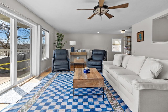 living area with a ceiling fan and wood finished floors