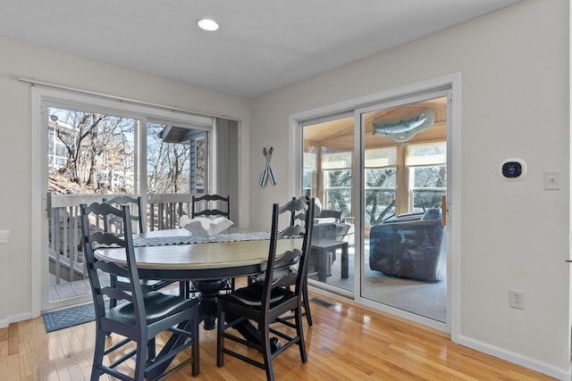 dining space featuring a wealth of natural light, baseboards, and wood finished floors