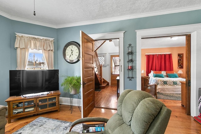355 W Mill St, Columbus, WI 53925 - living area featuring wood finished floors, crown molding, stairs, a textured ceiling, and plenty of natural light