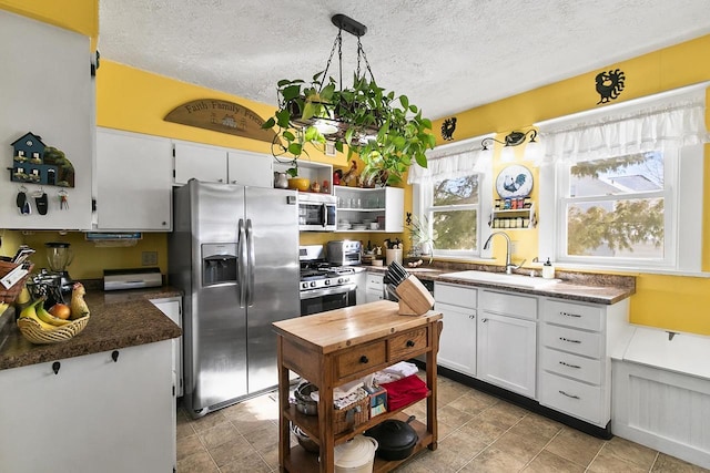 355 W Mill St, Columbus, WI 53925 - kitchen featuring appliances with stainless steel finishes, white cabinets, a textured ceiling, and open shelves