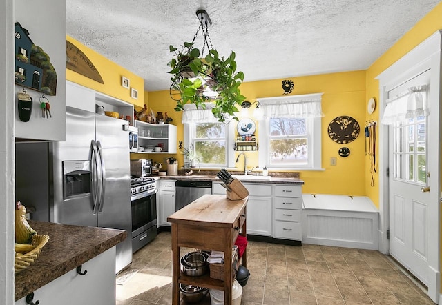 355 W Mill St, Columbus, WI 53925 - kitchen featuring open shelves, stainless steel appliances, a textured ceiling, white cabinets, and wood counters