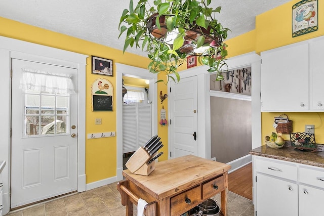 355 W Mill St, Columbus, WI 53925 - kitchen featuring a textured ceiling, white cabinets, and dark countertops