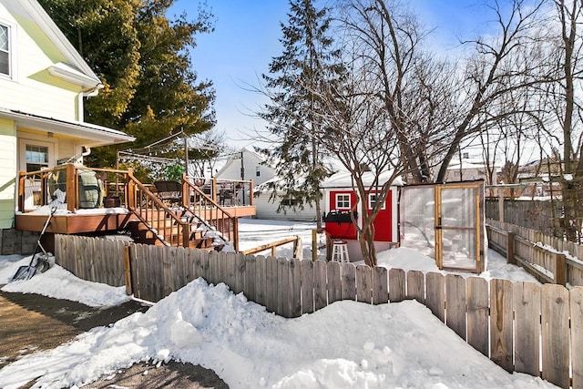 355 W Mill St, Columbus, WI 53925 - snowy yard featuring a fenced backyard, a deck, an outdoor structure, and stairway