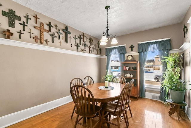355 W Mill St, Columbus, WI 53925 - dining area with plenty of natural light, a chandelier, wood-type flooring, and a textured ceiling