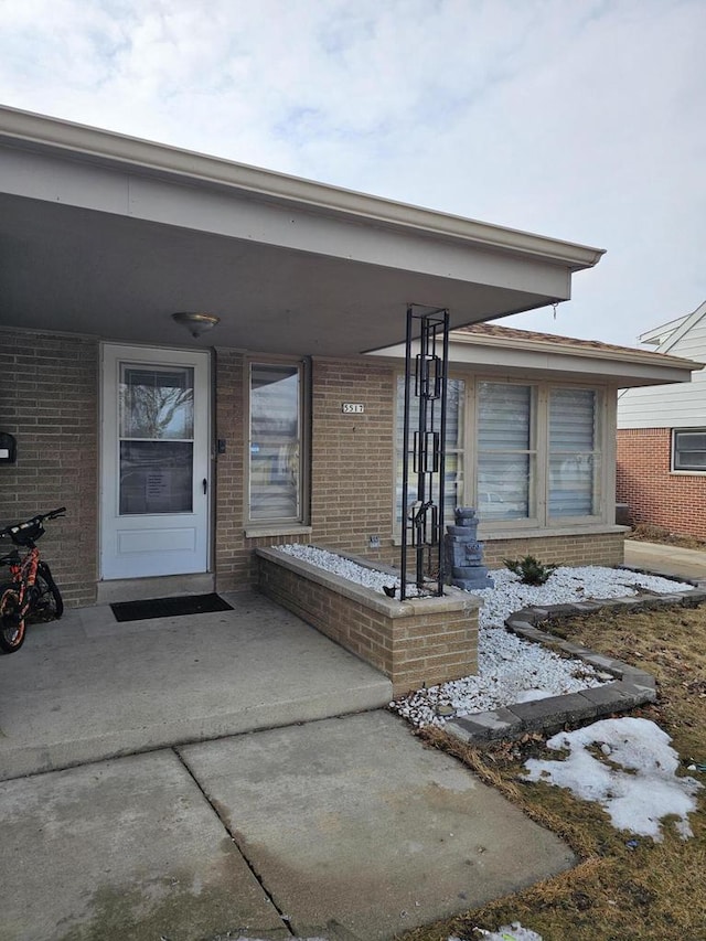 entrance to property featuring brick siding