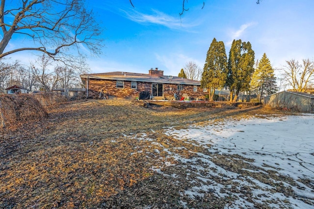 snow covered property with a chimney