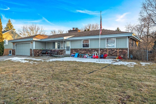 view of front of home with an attached garage, brick siding, concrete driveway, a chimney, and a front yard