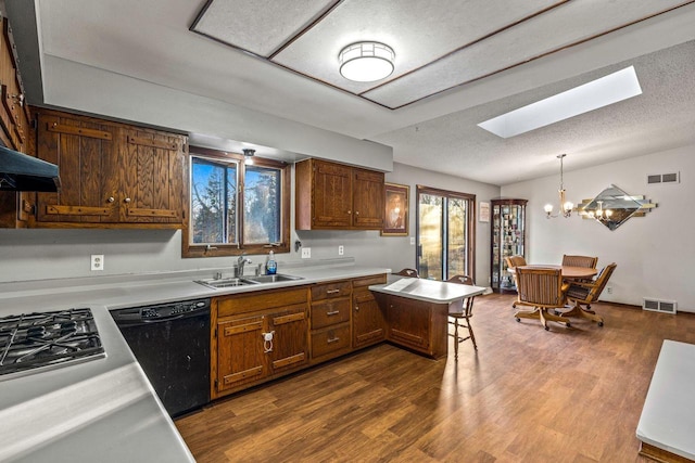 kitchen with visible vents, dishwasher, light countertops, pendant lighting, and a sink