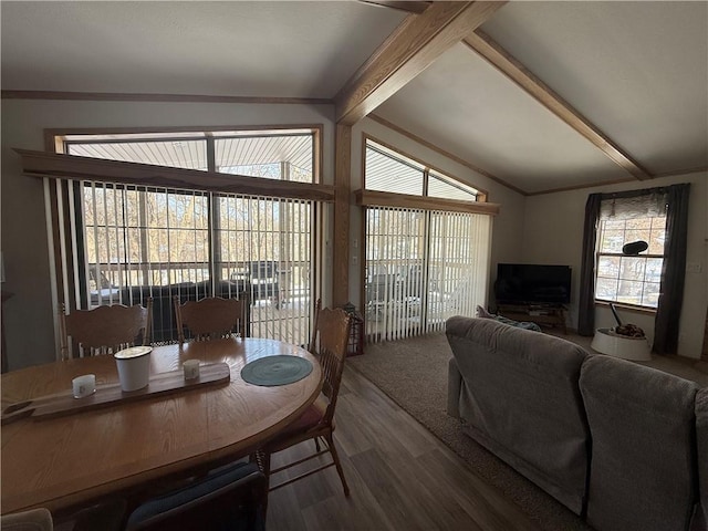 dining space with lofted ceiling with beams and wood finished floors