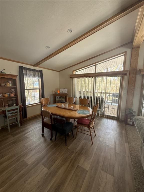 dining space with dark wood finished floors, lofted ceiling, ornamental molding, a textured ceiling, and baseboards