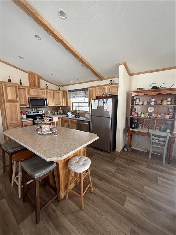 kitchen with stainless steel appliances, a breakfast bar, a center island, and light countertops