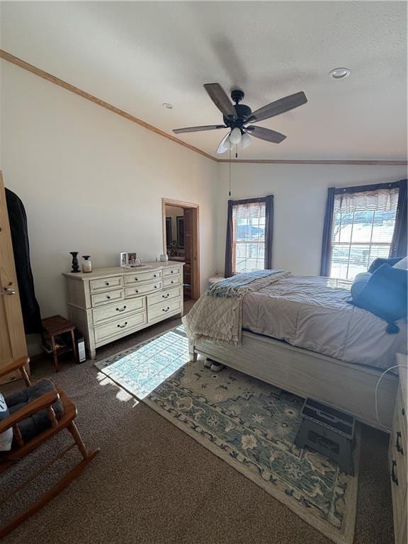 bedroom with ceiling fan, dark colored carpet, and crown molding