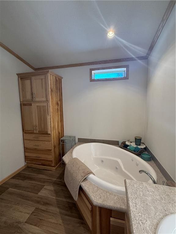 full bath with ornamental molding, baseboards, a whirlpool tub, and wood finished floors