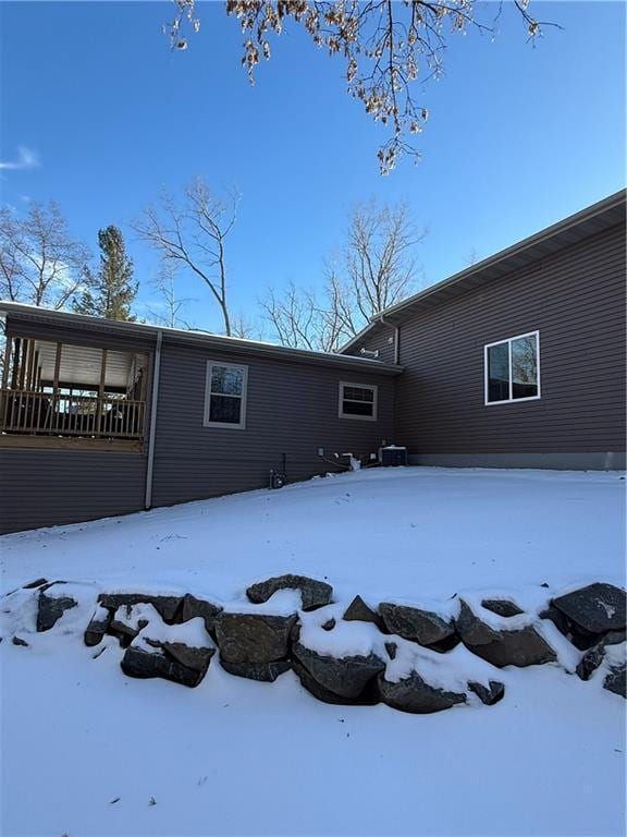 snow covered rear of property with a garage