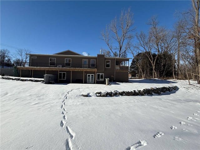 snow covered rear of property featuring a deck