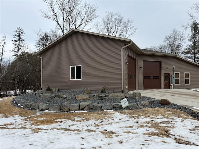 view of snowy exterior with an attached garage