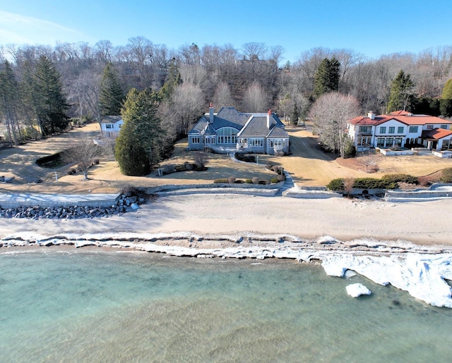 birds eye view of property with a wooded view and a water view