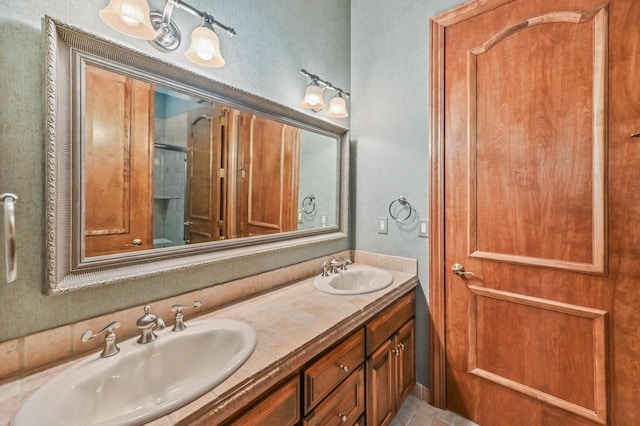 bathroom with a sink, a shower with shower door, and double vanity