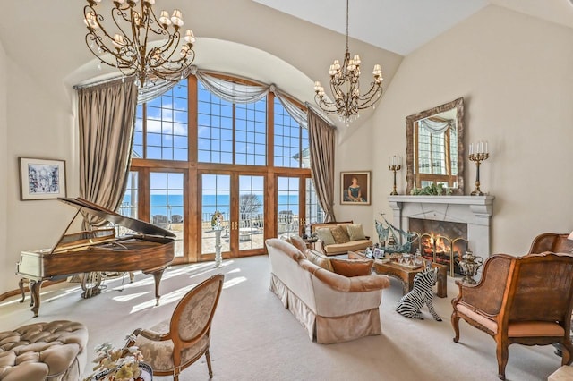 living room with carpet floors, high vaulted ceiling, an inviting chandelier, and a warm lit fireplace