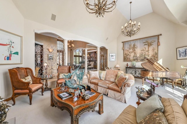 living area with carpet, ornate columns, high vaulted ceiling, arched walkways, and a notable chandelier