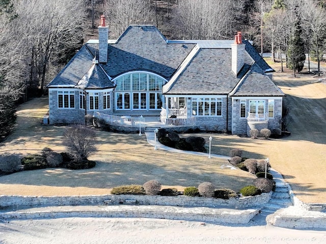 view of front facade with stone siding and a chimney