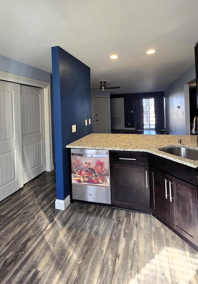 kitchen featuring dishwasher, dark wood-style floors, light stone countertops, dark brown cabinets, and a sink