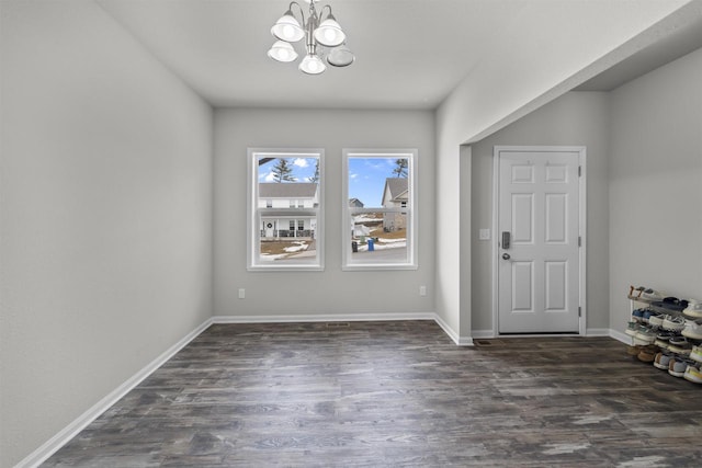 entrance foyer featuring dark wood-style floors, baseboards, and a chandelier