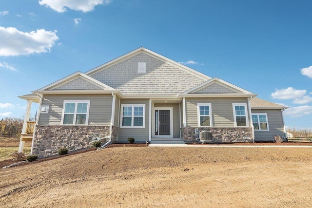 craftsman inspired home featuring central air condition unit and stone siding