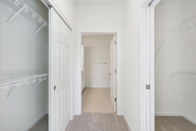 corridor with light carpet and baseboards