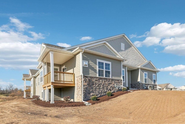 view of front of house featuring stone siding and a balcony