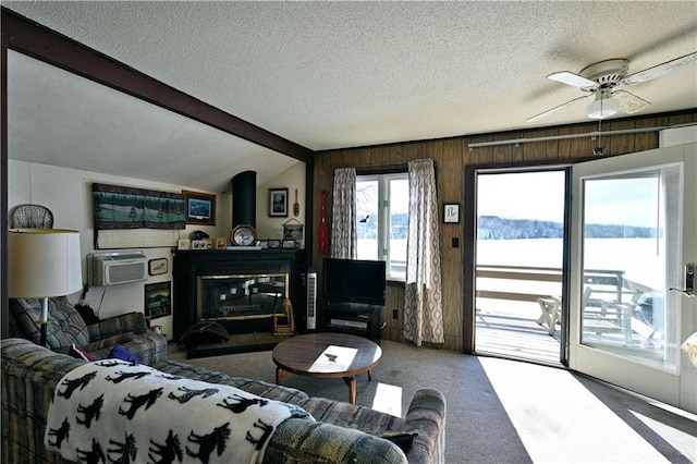 carpeted living area with vaulted ceiling with beams, a textured ceiling, and a ceiling fan