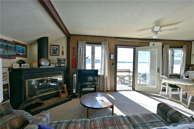 carpeted living room featuring lofted ceiling with beams, a textured ceiling, and plenty of natural light