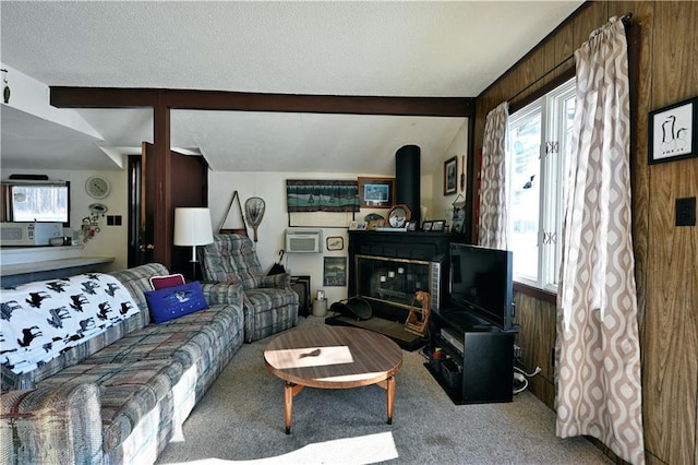 living area with vaulted ceiling with beams, plenty of natural light, wooden walls, and carpet flooring