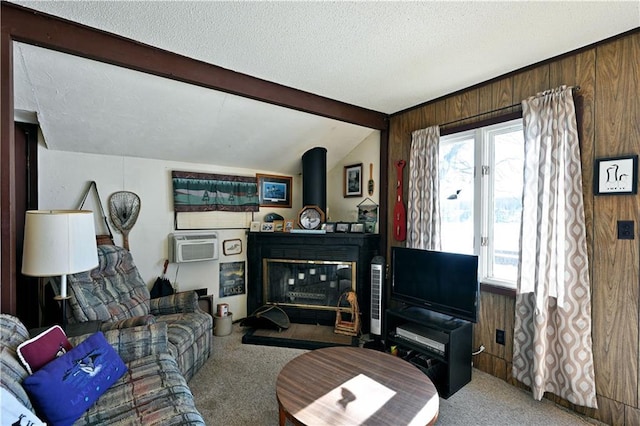 carpeted living area with lofted ceiling with beams, wood walls, plenty of natural light, and a textured ceiling