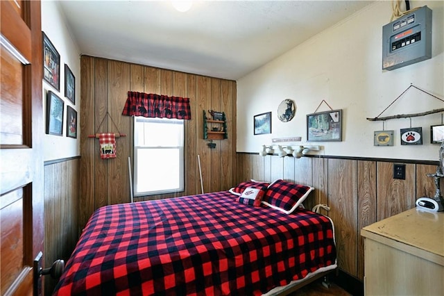 bedroom with a wainscoted wall and wooden walls