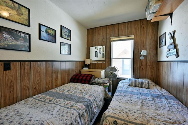 bedroom with wainscoting and wooden walls