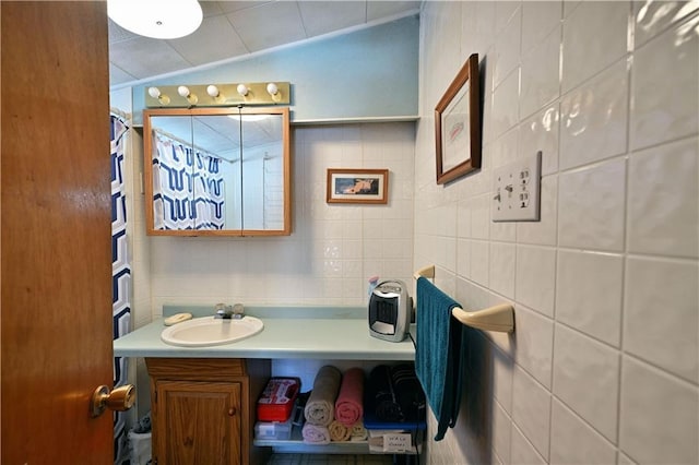 bathroom featuring vaulted ceiling, tile walls, and vanity