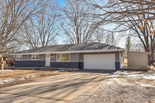 ranch-style home featuring a garage, stone siding, and driveway